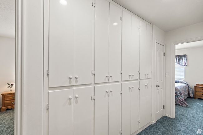 Hallway with view of two bedrooms and built-in cabinets. | Image 23