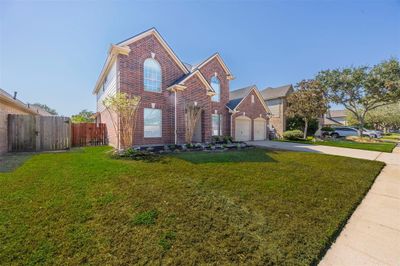 This lovely home boasts a large front yard, perfect for outdoor fun and relaxation | Image 3