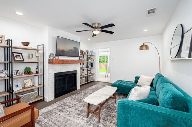 The living room has a focal fireplace and generous wall space for your furniture. | Image 8
