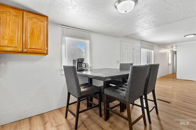 Dining area with a textured ceiling, a textured wall, and light wood-type flooring | Image 10