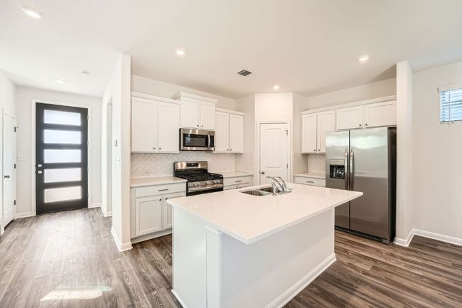 Kitchen featuring a center island with sink, white cabinets, appliances with stainless steel finishes, and a sink | Image 8
