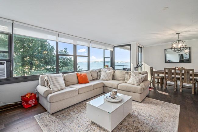 Living area with wood-type flooring, healthy amount of natural light, ornamental molding, and a water view | Image 10