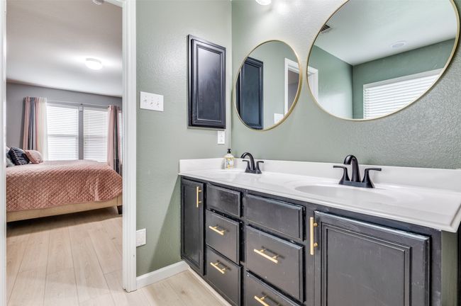 Primary bathroom with double vanity, wood finished floors, ensuite bathroom, and a textured wall. | Image 31