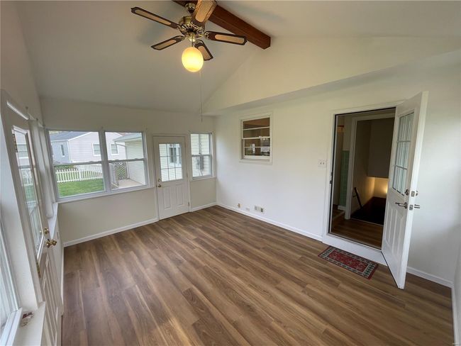 Unfurnished room with lofted ceiling with beams, baseboards, a healthy amount of sunlight, and wood finished floors | Image 41