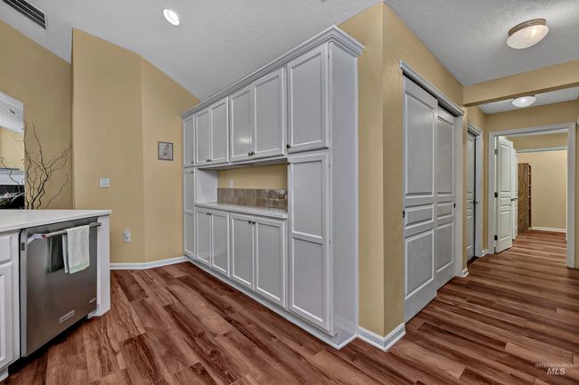 Kitchen with stainless steel dishwasher, dark wood-style floors, light countertops, and vaulted ceiling | Image 15