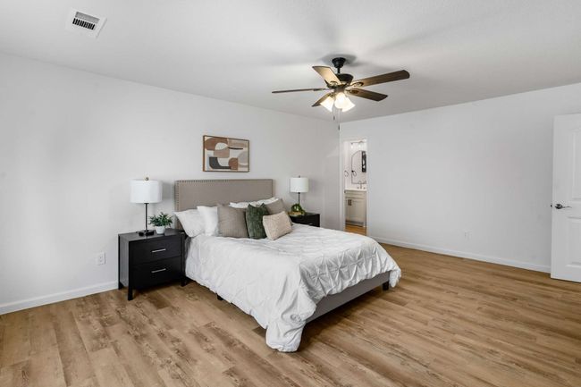 Bedroom featuring light wood-style floors, baseboards, connected bathroom, and ceiling fan | Image 13
