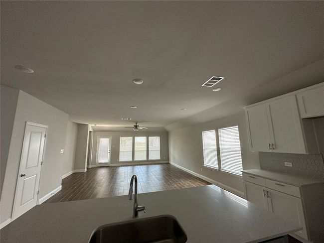 Kitchen with white cabinetry, ceiling fan, dark wood-type flooring, recessed lighting, and light countertops | Image 4