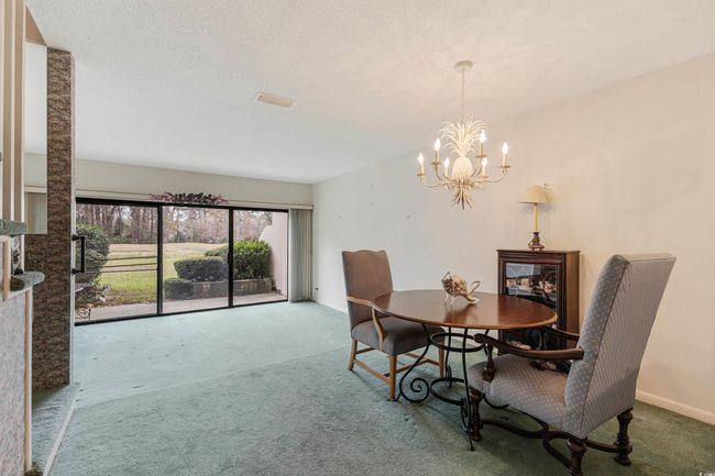 Dining area with baseboards, an inviting chandelier, and carpet | Image 11