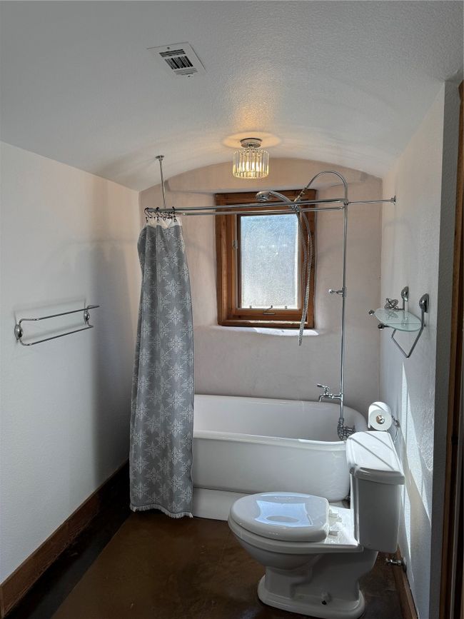 Bathroom featuring toilet, vaulted ceiling, shower / bath combo, and baseboards | Image 15