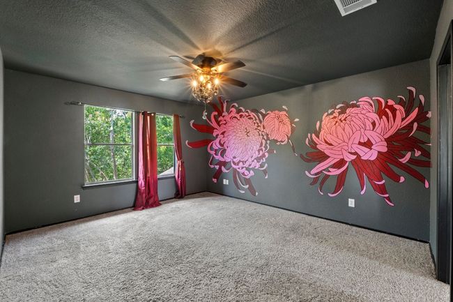 The roomy primary suite features a stylish light fixture/ceiling fan combo and a high ceiling. | Image 16