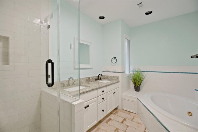 Primary ensuite with a glass enclosed walk-in shower, large soaking tub, and double sinks. | Image 18