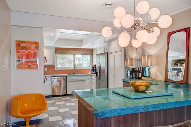 Kitchen with stainless steel appliances, light floors, a sink, and white cabinetry | Image 22
