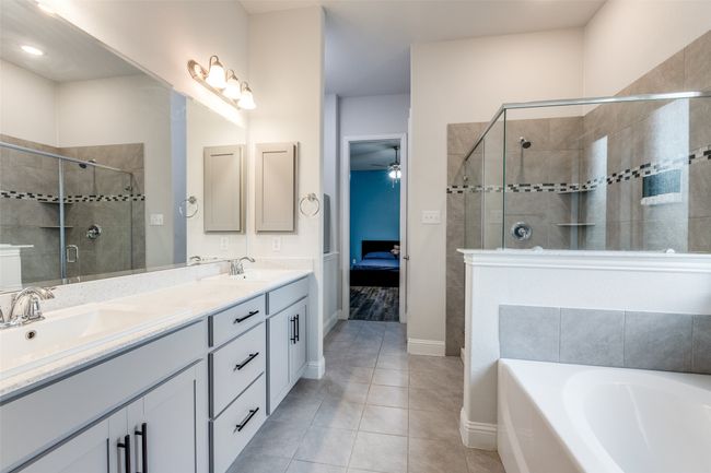 Ensuite bathroom with a stall shower, ensuite bath, ceiling fan, and a sink | Image 22