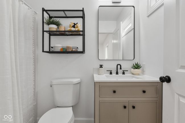 full bathroom featuring toilet, curtained shower, and vanity | Image 46