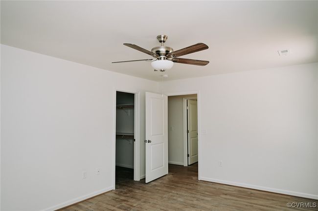 Unfurnished bedroom with a closet, ceiling fan, a spacious closet, and hardwood / wood-style flooring | Image 15