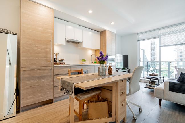 Kitchen with a breakfast bar, floor to ceiling windows, white cabinetry, recessed lighting, and light wood finished floors | Image 9