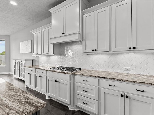 Chef's eat-in island kitchen features 42" cabinets with crown molding, under cabinet lighting, designer backsplash, stainless steel appliances and legthy countertops | Image 8