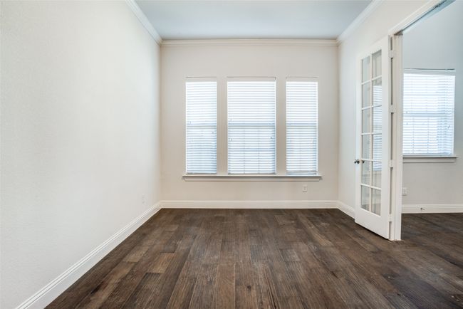 Unfurnished room featuring dark wood-type flooring, crown molding, plenty of natural light, and french doors | Image 15