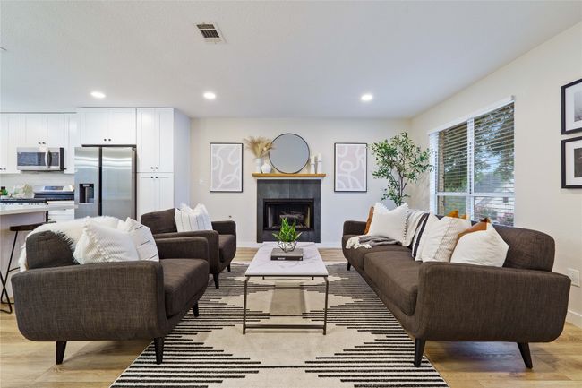 Living area with visible vents, light wood-style floors, baseboards, recessed lighting, and a fireplace | Image 4
