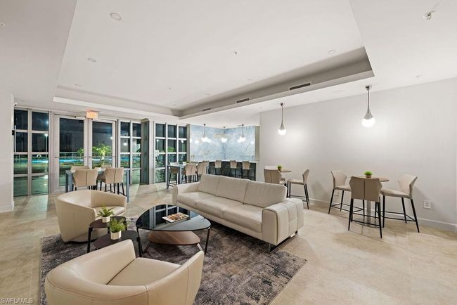 Tiled living room with a wall of windows and a raised ceiling | Image 30