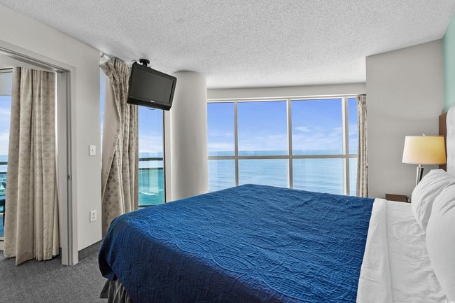 Carpeted bedroom with a textured ceiling | Image 18