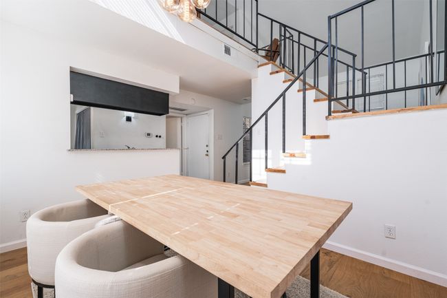 Dining space featuring baseboards, wood finished floors, stairway, and a towering ceiling | Image 7