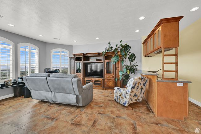 Living room with baseboards, stone finish flooring, recessed lighting, and a textured ceiling | Image 22