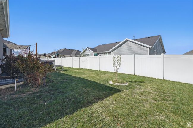 View of yard with a trampoline, a residential view, and fence | Image 51