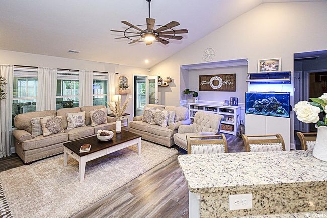 Living room with lofted ceiling, wood-type flooring, and ceiling fan | Image 7