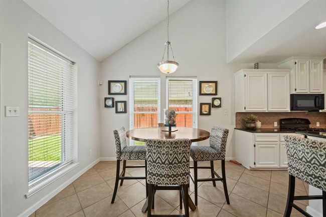 Located just off the kitchen, the breakfast area features neutral tile flooring, soft paint tones, and a stylish light fixture overhead. | Image 18