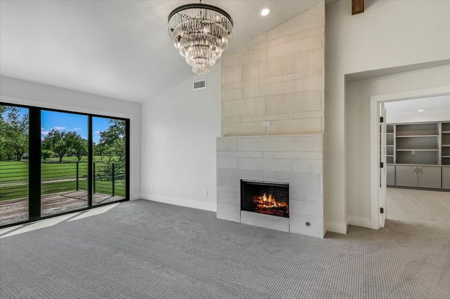Primary bedroom with vaulted ceilings, fireplace and expansive view of hill country and golf course | Image 9