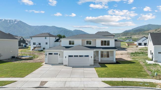 View of front of home with an attached garage, a mountain view, driveway, and a front lawn | Image 45