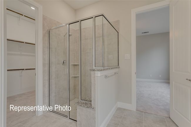 Full bath featuring a tile shower, a spacious closet, and tile patterned floors | Image 11