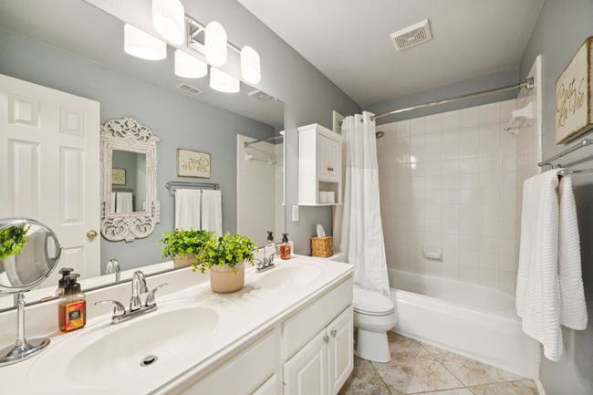 Full bathroom featuring shower / tub combo with curtain, double vanity, and tile patterned floors | Image 30