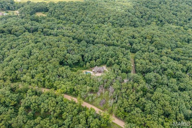 Aerial view of property and surrounding area featuring a heavily wooded area | Image 87