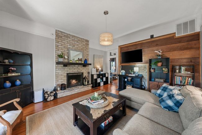 Living area featuring wood finished floors, wood walls, and a fireplace | Image 11