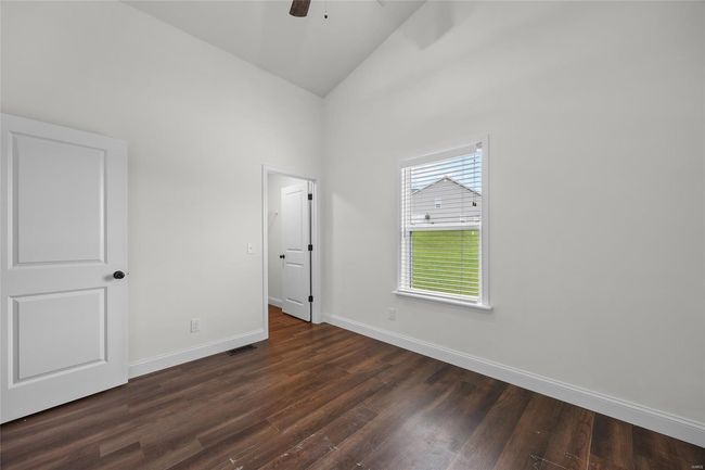 Unfurnished bedroom featuring visible vents, baseboards, high vaulted ceiling, dark wood-type flooring, and a ceiling fan | Image 15