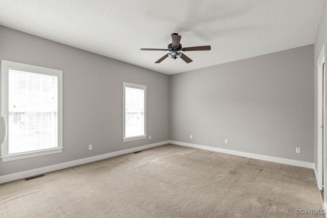 Unfurnished room with a ceiling fan, light carpet, baseboards, and a textured ceiling | Image 26