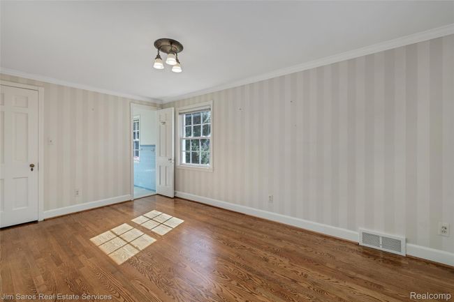 Spare room with ornamental molding and wood finished floors | Image 20