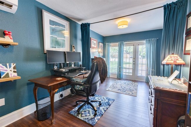 Office space featuring french doors, wood finished floors, a textured wall, a wall mounted air conditioner, and baseboards | Image 11