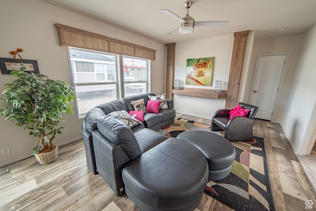 Living room featuring ceiling fan, baseboards, and light wood-type flooring | Image 50