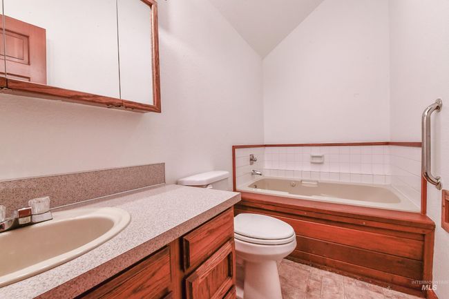 Full bathroom featuring a garden tub, vanity, and vaulted ceiling | Image 18