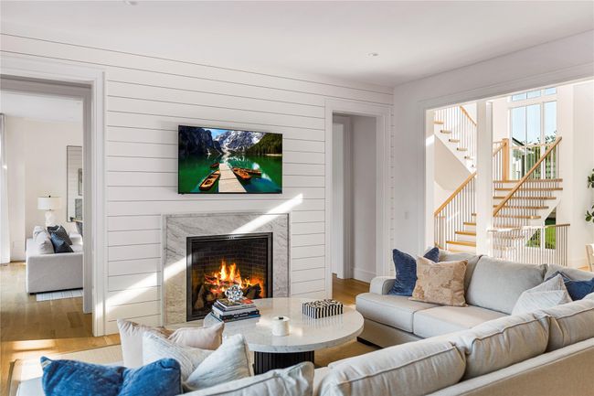 Living area featuring a high end fireplace, wood finished floors, stairs, and wooden walls | Image 11