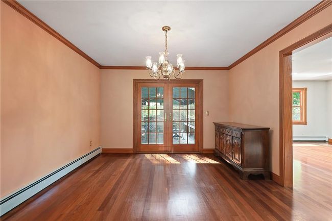 Unfurnished dining area with french doors, dark hardwood / wood-style flooring, a notable chandelier, and baseboard heating | Image 7