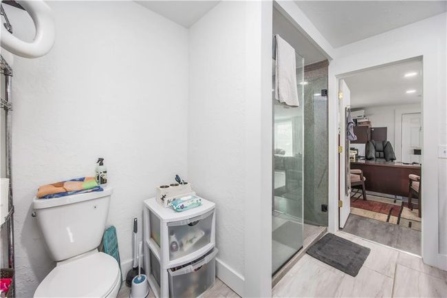 Full bathroom featuring a shower stall, toilet, and baseboards | Image 12