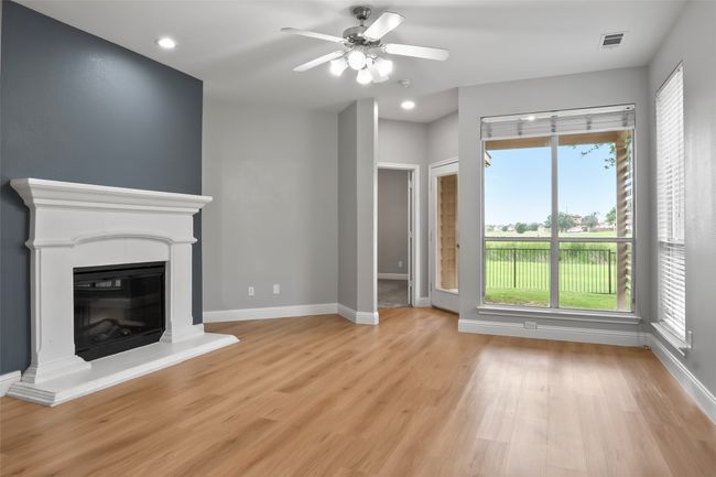 Unfurnished living room featuring light wood-style floors, a ceiling fan, baseboards, a glass covered fireplace, and recessed lighting | Image 14