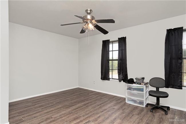 Home office with wood finished floors, ceiling fan, and baseboards | Image 15