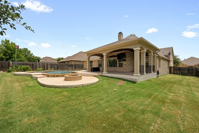 Back of property with a patio area, a fenced backyard, a chimney, and brick siding | Image 33