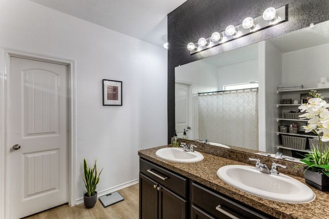 Bathroom with double vanity, wood finished floors, and a shower with curtain | Image 26