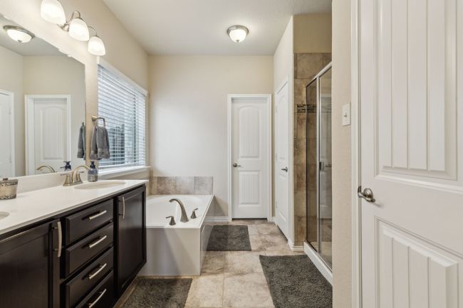 Full bathroom featuring a shower stall, a garden tub, and double vanity | Image 15